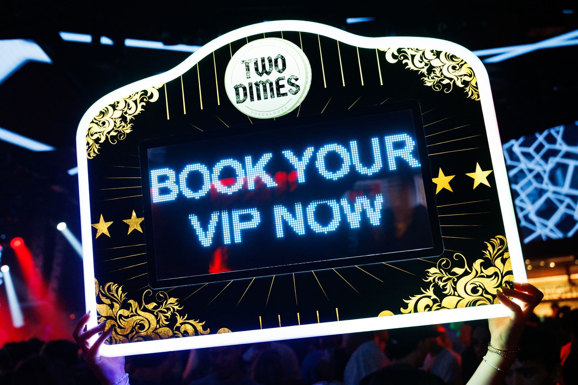 The Book Your VIP sign lit in front of the LED wall
